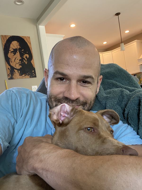 The owner of Mr Bubs Poop Scooping at home, hugging Mr Bubs